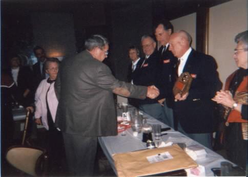 Retired Camanche Fire Chief Bill Rowe accepts Roger Mooty award from President Charles M. Conklin at the 2002 Fall Conference in Algona.
